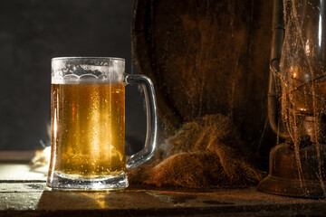 Mug with fresh light beer with foam on wooden vintage background with barrel