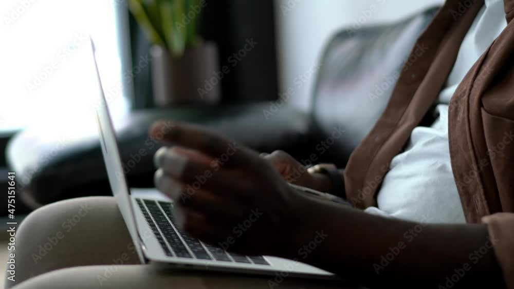 Poster cropped view, african american guy sitting with notepad and open laptop computer while taking notes.