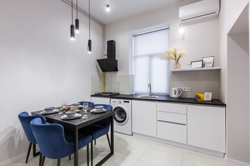 Interior of a small bright kitchen in a small modern apartment with white walls