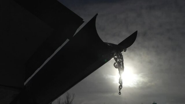 snow melts and water drops drip from the old roof of the house