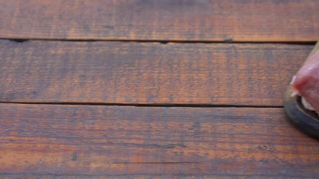 Close up view 4k stock video footage of fresh raw pork meat isolated on brown wooden rustic table background