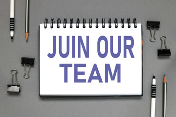 join our team. text on a notebook that lies on a gray background