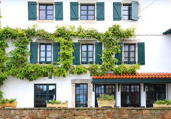 Fototapeta na wymiar fachada de casa con ventanas verdes en ascain pueblo vasco francés francia 4M0A7741-as21