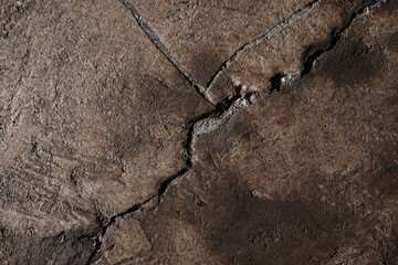 Brown textured clay wall design with cracks and imperfections. Wall design ideas in contemporary interior.