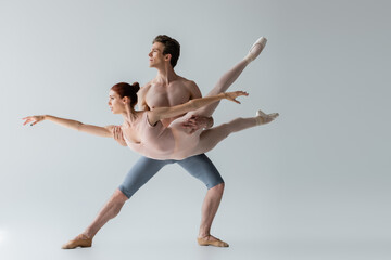 shirtless ballet dancer lifting young ballerina isolated on grey © LIGHTFIELD STUDIOS