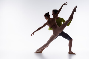 Fototapeta na wymiar full length of flexible ballet dancers performing dance on white