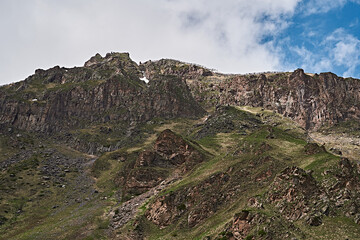 Fototapeta na wymiar Elbrus mountains in May. Snow, greenery, brown earth