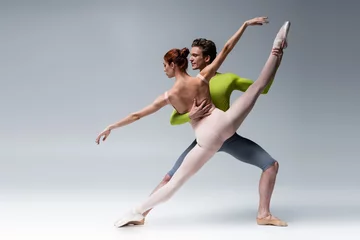 Fotobehang full length of man and flexible woman performing ballet dance on grey © LIGHTFIELD STUDIOS