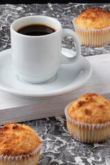 Brazilian queijadinha served  with coffee.