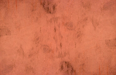 Red concrete wall surface with scattered black spots for background