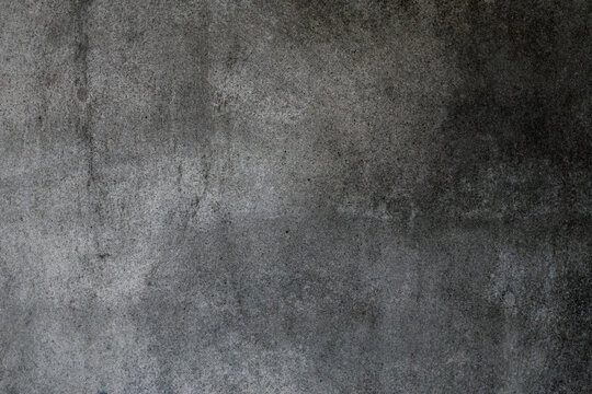 Dark sandy plaster wall surface with grunge texture for background