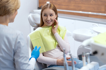 Smiling woman after teeth treatment procedure in contemporary clinic office