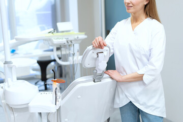 Dentist standing in contemporary clinic near dental equipment