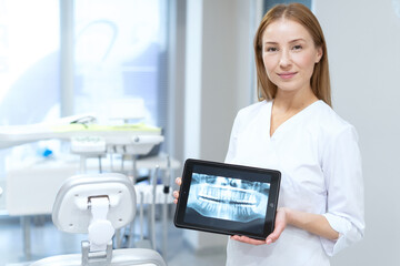 Beautiful dentist with tooth panoramic x-ray image on tablet