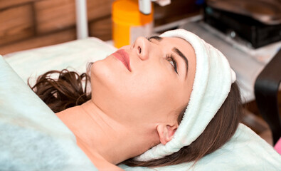 The girl at the beautician makes spa treatments, massage, facial cleansing and a mask for the skin....