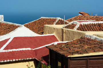 Roofs, geometric shapes and colours under a deep blue sky.