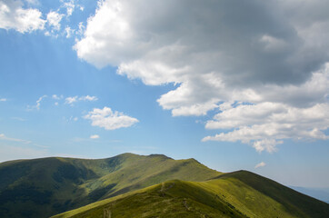 Hiking trail along the mountain range. Path through grassy alpine mountain slopes. Beautiful landscape of carpathians Ukraine