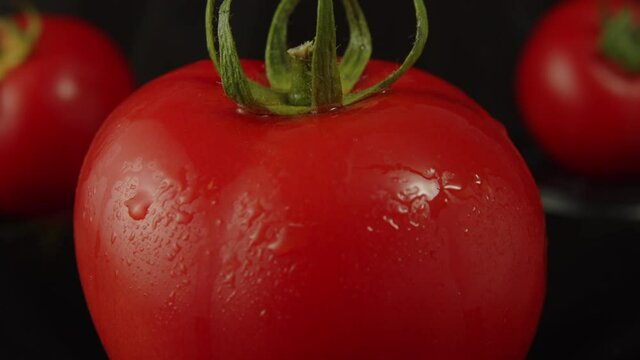 Close up shot of a rotating fresh tomato on black background