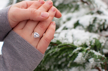 women's hands with a ring with a large gemstone on a blurred background with a place for text