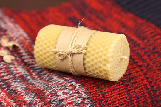 Handmade Beeswax Candle With Craft Paper Wrapper On Christmas Red Knitted Sweater. Honey Aroma For Interior And Tradition. Mockup, Front View.