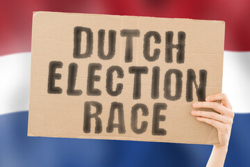 The phrase " Dutch election race " on a banner in men's hand with blurred Dutch flag on the background. Ballot box.  Politics. Conflict. Politic. Primary. Selection. Choosing. Rotterdam