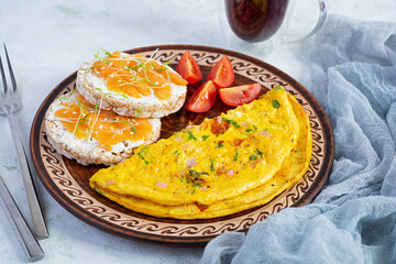 Fried omelette with beef and herbs. Delicious breakfast with eggs, puffed rice cakes and salmon