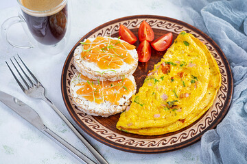 Fried omelette with beef and herbs. Delicious breakfast with eggs, puffed rice cakes and salmon
