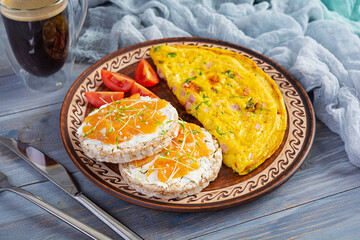 Fried omelette with beef and herbs. Delicious breakfast with eggs, puffed rice cakes and salmon