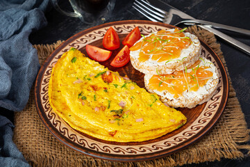 Fried omelette with beef and herbs. Delicious breakfast with eggs, puffed rice cakes and salmon