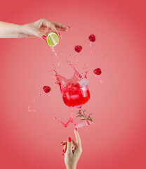 Woman hand support fly glass of raspberry drink with splash, juice raspberry falling in glass....