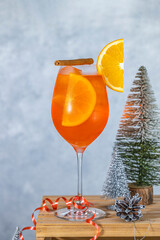 Italian cocktail aperol spritz in big wine glass with water drops on light Christmas or New Year...