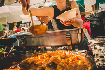 Cheff serving fusion international cusine on street stall on international street food festival of...
