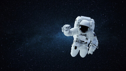 Spaceman in a white space suit with a helmet flies in open space against a background of stars and...