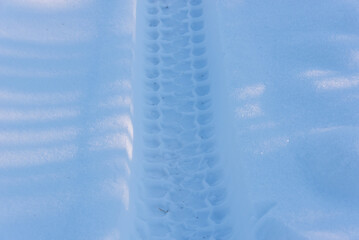 Trail of a car tire in the snow. Tractor tracks.
