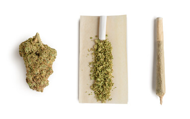 Marijuana bud ,crushed bud of marijuana on the rolling paper and rolling cannabis joint. Isolated...