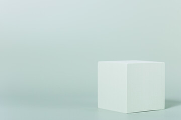 Cube podium on green background with copy space