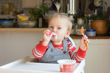 18 month old self feeding yogurt from the cup; messy but independent