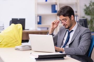 Young male employee looking after new born at workplace