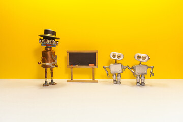 Artificial intelligence and machine learning concept. Robotics teacher, small robots students and toy black chalkboard on yellow white background.