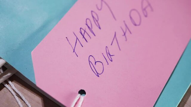 Happy birthday hand written on a gift tag 