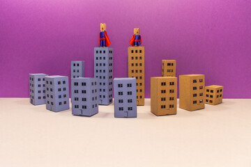 Teamwork guarding and protecting the city. Super hero clothespin characters on the rooftops, looks around. Powerful town defenders guards, miniature paper building landscape. Abstract paper houses