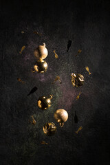 Festive composition of golden balls and ornaments, shiny ornament on a dark background. New Year and Christmas concept. Levitation. Vertical position.