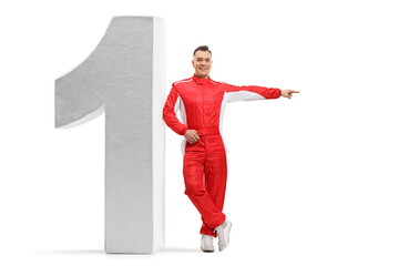 Full length portrait of a racer in a red suit leaning on number one and pointing to the side