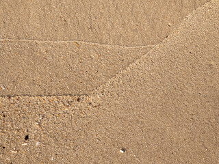 Wet sand with delicate lines created by ocean waves that resemble trend graphs. Illustration concept for business.