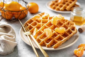Homemade ginger waffles with tangerines. Delicious Christmas pastries on a light background closeup	