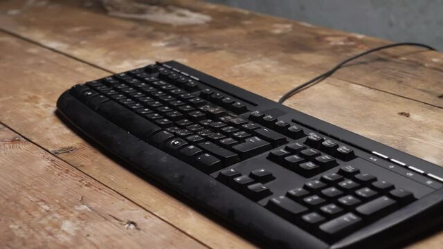 Sledge hammer hitting computer keyboard. Damage keyboard. Broken office equipment. Old computer keyboard with smashed buttons. Garbage concept.