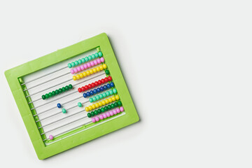 Colorful bead calculator on white. Green plastic manual bead counter for math. Colourful beaded abacus. School education, Calculator for preschool maths