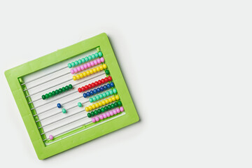 Colorful bead calculator on white. Green plastic manual bead counter for math. Colourful beaded...