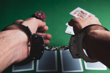 a man in handcuffs sits at a poker table