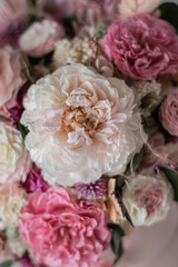 Beautiful composition with pink, white flowers and eucalyptus. Beautiful bouquet of pink roses in a festive round box on a gray background.